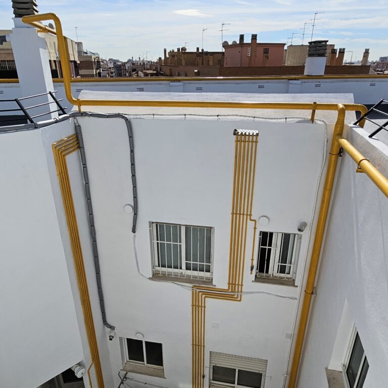 Perspectiva de un patio interior con estructura metálica y tuberías