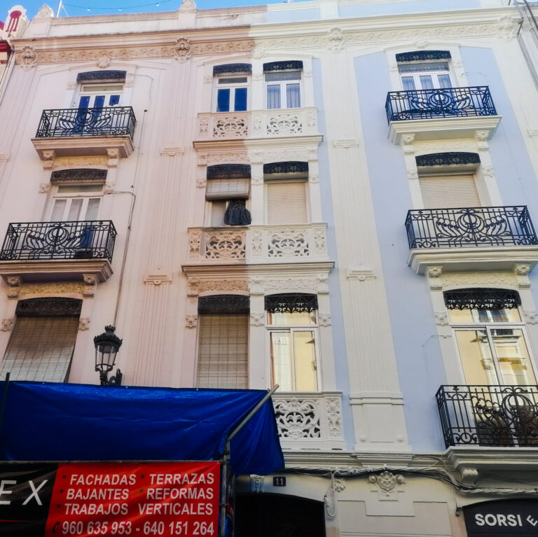 Edificio restaurado con balcones de hierro forjado y fachada blanca