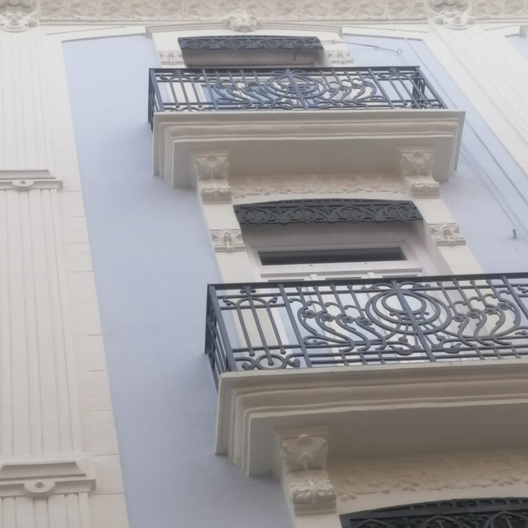 Detalle de balcones restaurados con barandillas de hierro negro