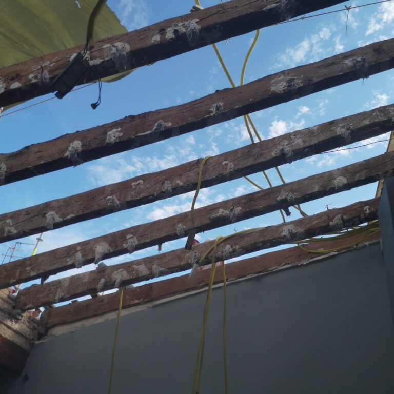 Estructura de cubierta con vigas de madera deterioradas