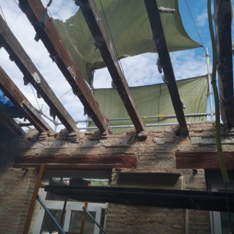 Restauración de techo con vigas dañadas y restos de yeso